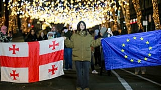 Demonstranten mit der georgischen Nationalflagge und einer EU-Flagge bei einer regierungskritischen Kundgebung der scheidenden Präsidentin Surabischwili in Tiflis