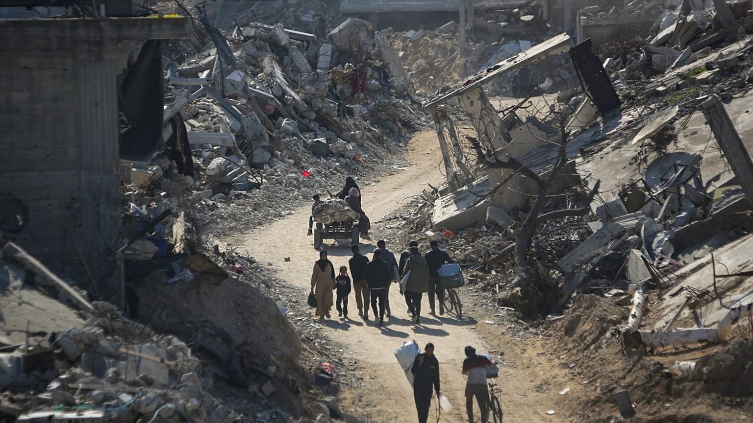فلسطينيون عائدون يسيرون بين أنقاض المنازل المدمرة جراء قصف الجيش الإسرائيلي في بيت لاهيا، شمال قطاع غزة، الأربعاء، 29 يناير/كانون الثاني 2025