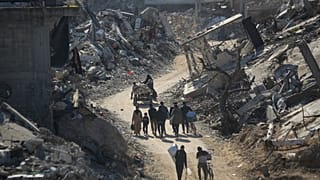 فلسطينيون عائدون يسيرون بين أنقاض المنازل المدمرة جراء قصف الجيش الإسرائيلي في بيت لاهيا، شمال قطاع غزة، الأربعاء، 29 يناير/كانون الثاني 2025