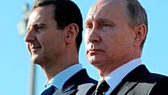 الرئيس الروسي فلاديمير بوتين والرئيس السوري بشار الأسد يراقبان القوات في قاعدة حميميم الجوية في سوريا، في 11 ديسمبر/ كانون الأول 2017.