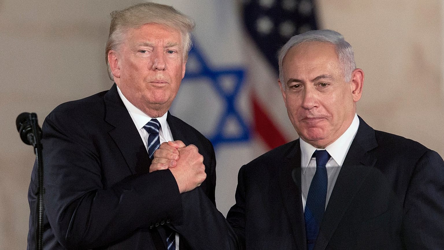 ARQUIVO - O Presidente Donald Trump e o Primeiro-Ministro israelita Benjamin Netanyahu apertam as mãos no Museu de Israel, em Jerusalém, a 23 de maio de 2017.