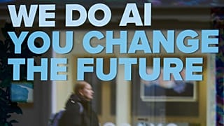 A woman is reflected in a window with a slogan about AI ahead of the World Economy Forum in Davos, Switzerland, Sunday, Jan. 19, 2025.
