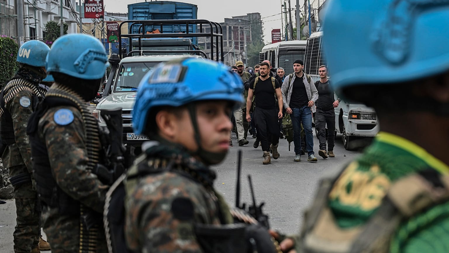 Os rebeldes do M23 escoltam mercenários romenos, passando pelas forças de manutenção da paz da ONU, até à fronteira com o Ruanda, em Goma, República Democrática do Congo, quarta-feira, 29 de janeiro de 2025.