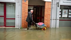 Um homem usa um carrinho de mão numa rua inundada devido à tempestade Ivo, quarta-feira, 29 de janeiro de 2014, em Redon, França, 29.01.2025
