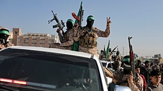 Толпа приветствует боевиков Исламского джихада и Хамаса, прибывших на передачу заложников Красному Кресту в городе Хан-Юнис на юге сектора Газа, 30 января 2025 г.