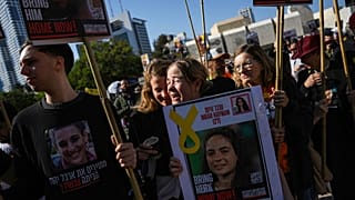 People react as they watch broadcast of the release of Israeli soldier Agam Berger, one of eight hostages set to be released today as part of a ceasefire in the Gaza Strip,