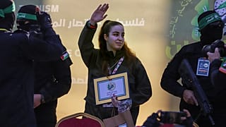 الرهينة الإسرائيلية أغام بيرغر تلوح بيدها أثناء تسليمها إلى الصليب الأحمر من قبل مقاتلين ملثمين من حركة الجهاد الإسلامي في مخيم جباليا للاجئين