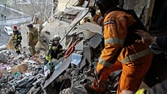 Спасатели ищут выживших при ударе российского беспилотника по жилому дому в Сумах, 30 января 2025 года.