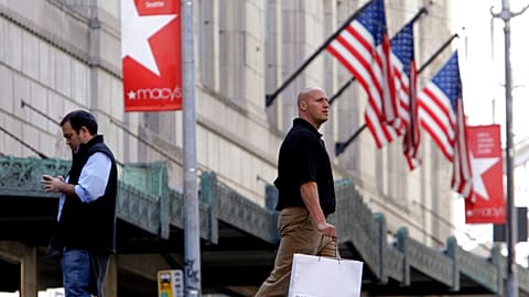 Shoppers walk past a Macy's store - FILE PHOTO