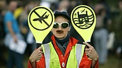 An environmental activist imitates an airport worker near London's Heathrow Airport