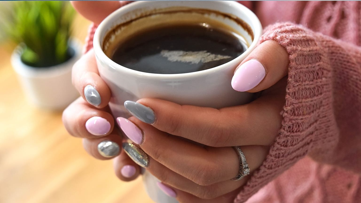 Una persona con in mano una tazza di caffè