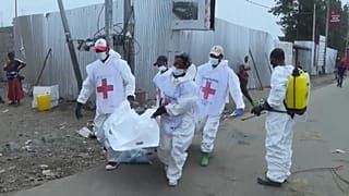 Des employés de la Croix-Rouge chargent des corps dans un camion à destination de la morgue de l'hôpital du nord de Goma.