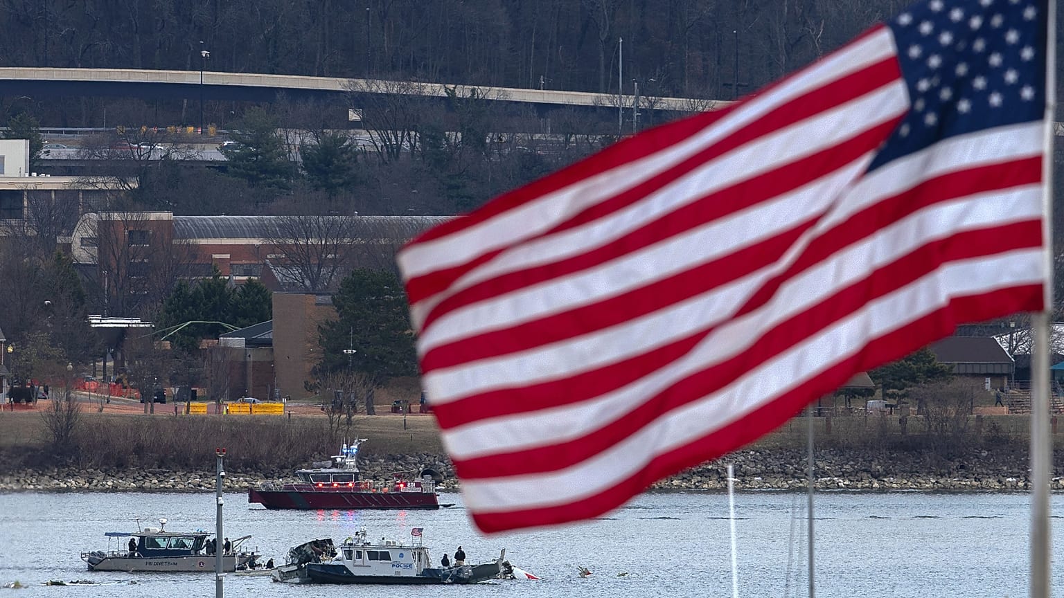 Une équipe de plongeurs et un bateau de police entourent l'épave de l'avion dans la rivière Potomac depuis l'aéroport national Ronald Reagan Washington, le 30 janvier 2025.