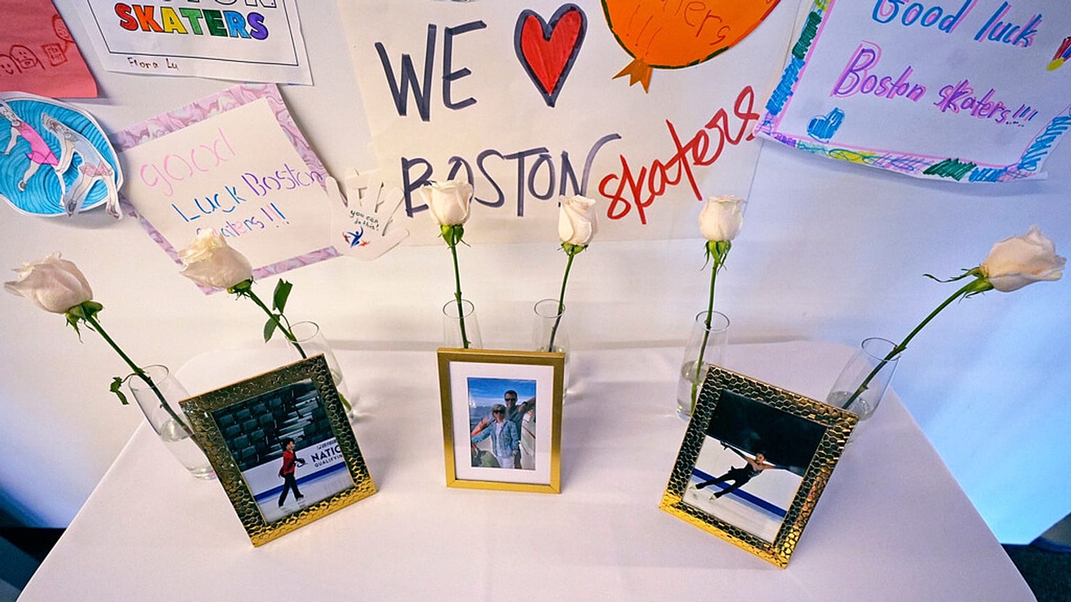 Seis rosas brancas e fotografias das vítimas estão expostas no The Skating Club of Boston, quinta-feira, 30 de janeiro de 2025, em Norwood, Massachusetts.