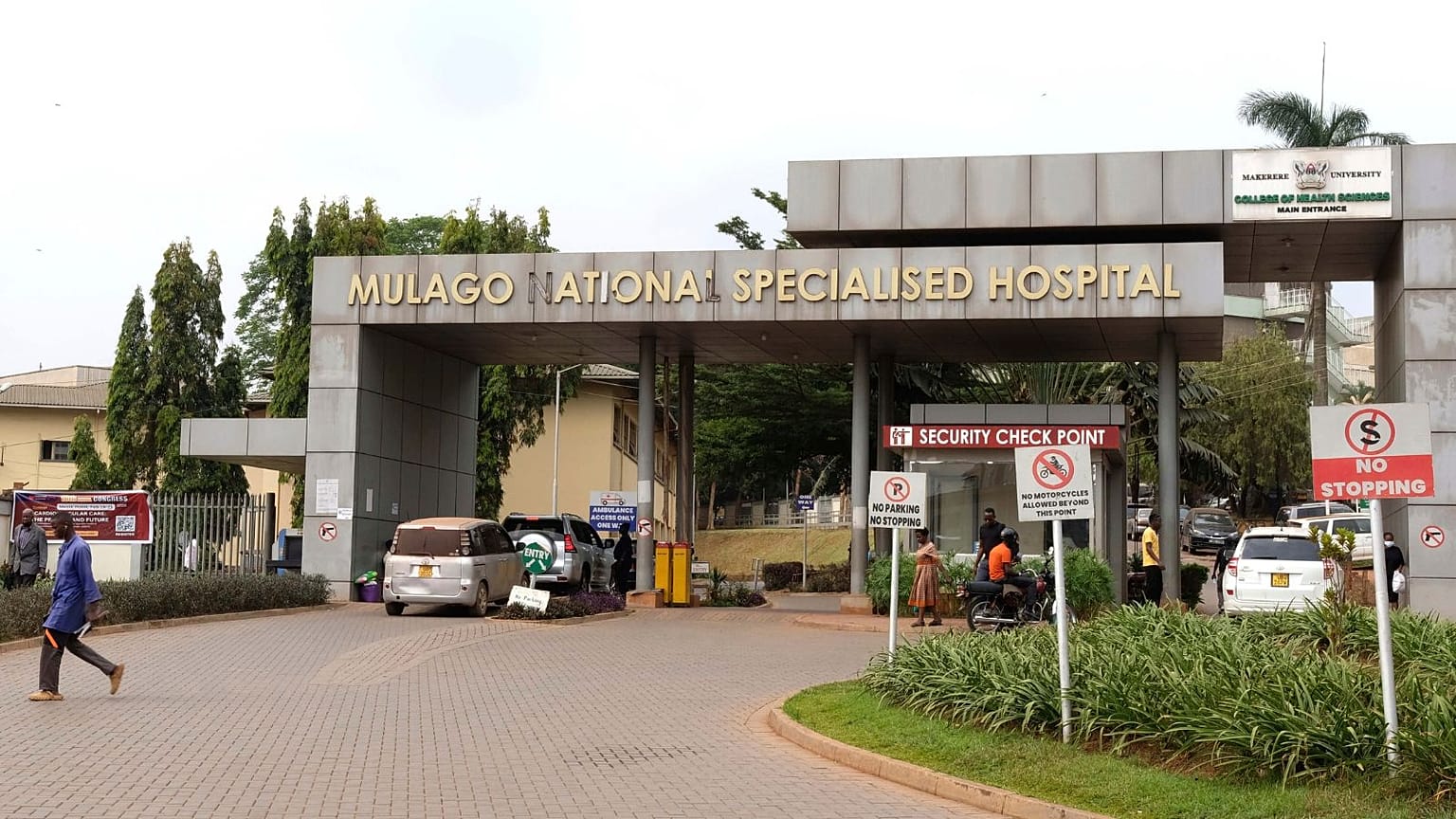 İnsanlar 30 Ocak 2024 Perşembe günü Uganda'nın Kampala kentinde bir hemşirenin Ebola nedeniyle hayatını kaybettiği Mulago Ulusal Hastanesi'nin önünde yürüyor.