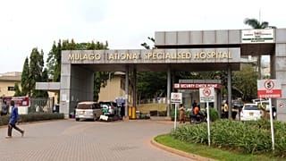 İnsanlar 30 Ocak 2024 Perşembe günü Uganda'nın Kampala kentinde bir hemşirenin Ebola nedeniyle hayatını kaybettiği Mulago Ulusal Hastanesi'nin önünde yürüyor.