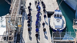 Una fotografia aerea scattata da un drone mostra dei migranti scortati dalla polizia italiana nel porto di Shengjin, nell'Albania nord-occidentale, 28 gennaio 2025
