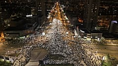 Pessoas seguram as luzes dos telemóveis durante um protesto em frente à estação ferroviária de Novi Sad, onde 15 pessoas morreram na sequência da queda de uma cobertura de betão, 31 de janeiro de 2025