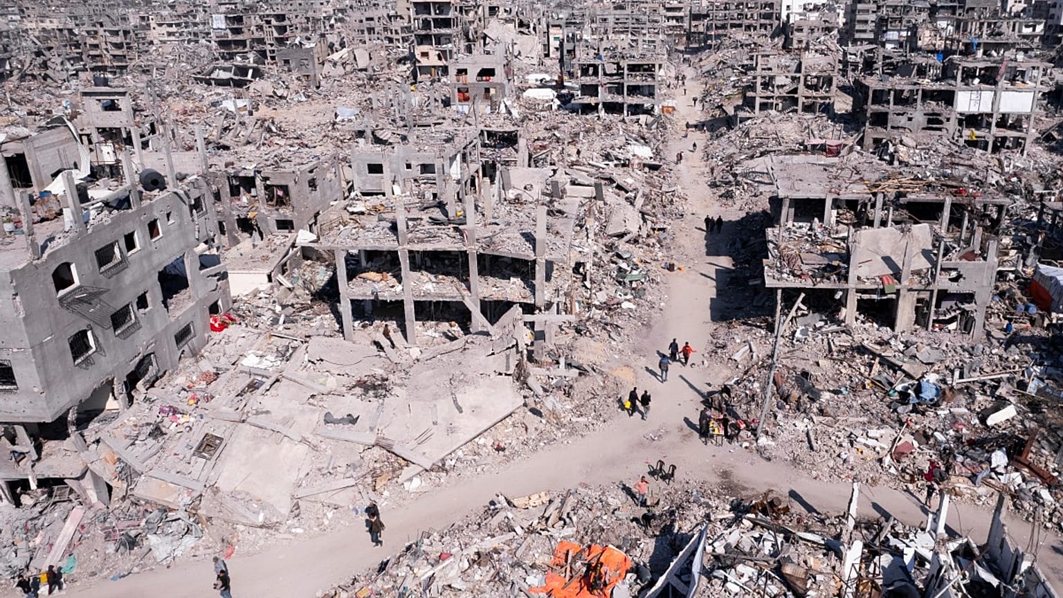  فلسطينيون يسيرون وسط الدمار الذي خلفه الهجوم الجوي والبري الإسرائيلي في جباليا، قطاع غزة، الأربعاء، 29 يناير/كانون الثاني 2025