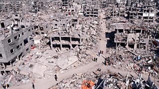  فلسطينيون يسيرون وسط الدمار الذي خلفه الهجوم الجوي والبري الإسرائيلي في جباليا، قطاع غزة، الأربعاء، 29 يناير/كانون الثاني 2025