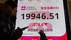 Pedestrians walk past an electronic screen displaying the Hang Seng Index on the first trading day of the Year of Snake in Hong Kong, Monday, Feb. 3, 2025. 