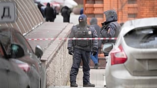Police officers stand guard in the yard of an upscale residential block in Moscow, 3 February 2025