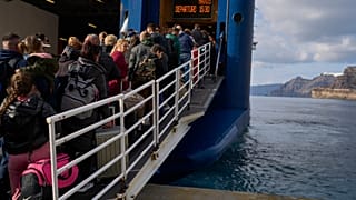 Passengers board a regularly scheduled ferry to Athens' port of Piraeus, after a spike in seismic activity raised concerns about a potentially powerful earthquake in Santorini
