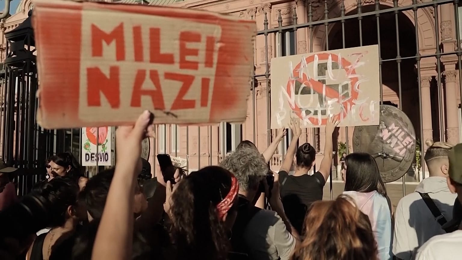 Manifestantes ante el edificio del Gobierno argentino sostienen un cartel de Milei Nazi.
