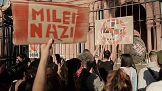 Manifestantes ante el edificio del Gobierno argentino sostienen un cartel de Milei Nazi.