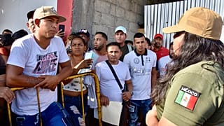 Ein mexikanischer Migrationsbeamter erklärt den Migranten, dass die Erlaubnis, durch Mexiko zur Grenze zwischen den USA und Mexiko zu reisen, ausgesetzt wurde.