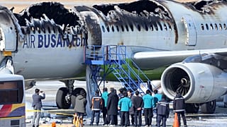 İtfaiyeciler ve diğer yetkililer, Güney Kore'nin Busan kentindeki Gimhae Uluslararası Havaalanında Air Busan uçağının alev aldığı bölgeyi ziyaret etti, 29 Ocak 2025.
