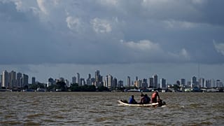 A boat sails on the bay of the Guama River with Belem, Brazil, in the background