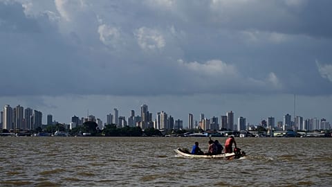 A boat sails on the bay of the Guama River with Belem, Brazil, in the background