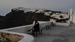 Bir turist, Yunan yetkililerin ülkenin güneyindeki popüler tatil adası Santorini'de yoğun sismik aktiviteye karşı acil önlemler alırken Firostefani'de oturuyor, 3 Şubat 2025.