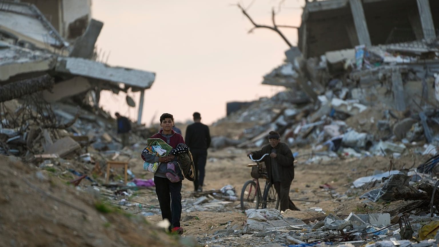 فلسطينيون يسيرون في أحد شوارع مدينة غزة المليئة بأنقاض المباني التي دمرت خلال الحرب، مدينة غزة، الثلاثاء 4 فبراير/شباط 2025