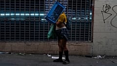 Una mujer sin hogar con problemas mentales camina con una caja en la cabeza por las calles de Los Ángeles.