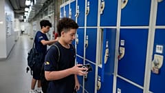 Μαθητές αποθηκεύουν τα κινητά τους τηλέφωνα σε θυρίδες καθώς κατευθύνονται προς την τάξη σύμφωνα με το νέο νόμο που περιορίζει τη χρήση τους στην πανεπιστημιούπολη στο σχολείο Porto Seguro στο Σάο Πάολο, Πέμπτη 6 Φεβρουαρίου 2025.