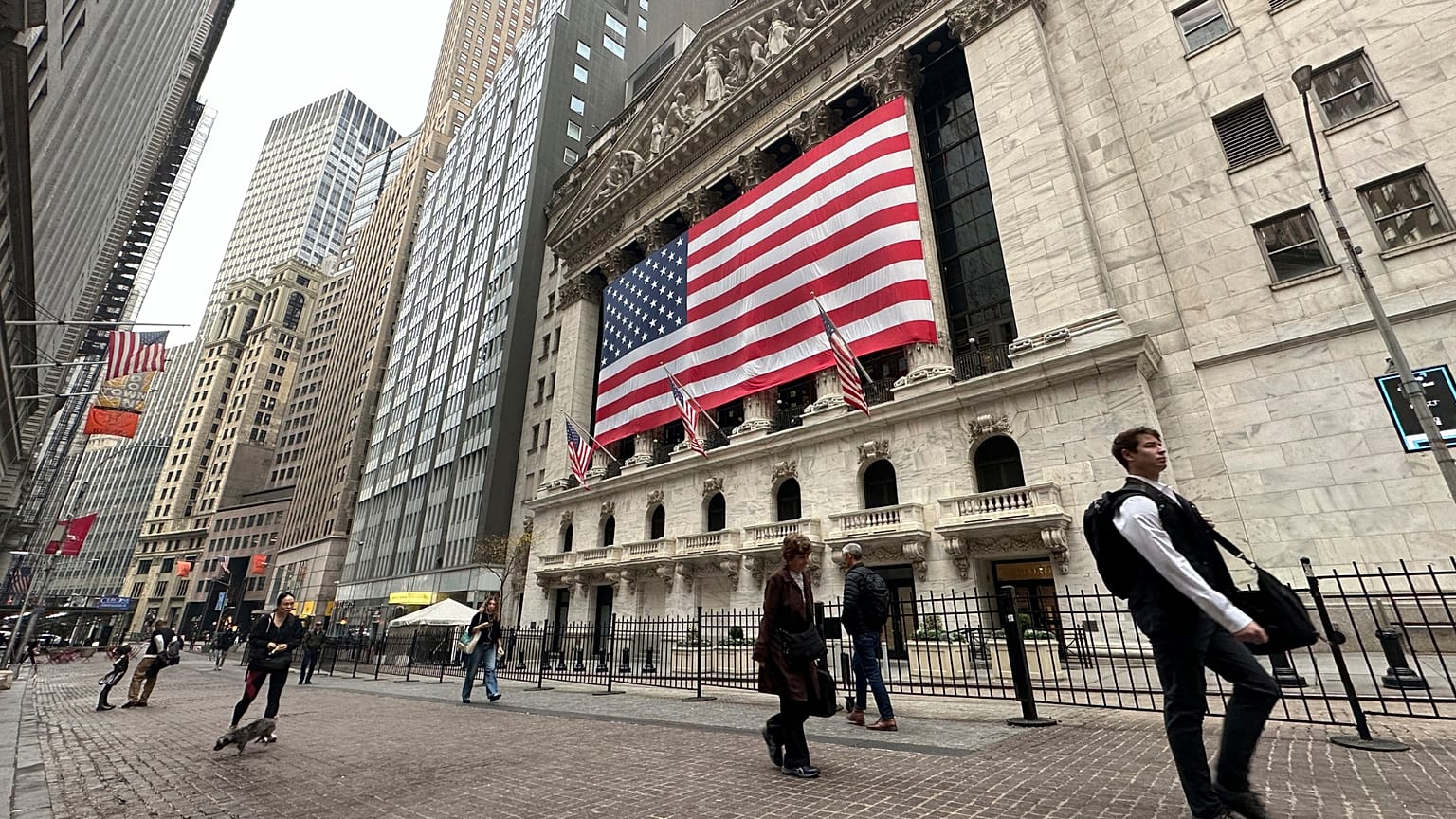 People pass the New York Stock Exchange in New York's Financial District.