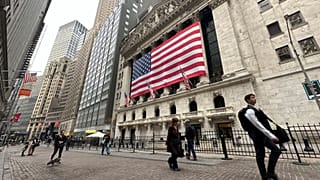 People pass the New York Stock Exchange in New York's Financial District.
