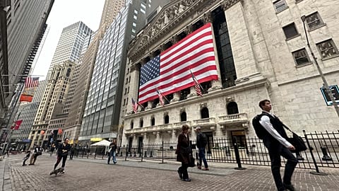 People pass the New York Stock Exchange in New York's Financial District.