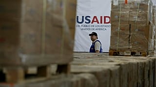 Um homem passa por caixas de ajuda humanitária da USAID num armazém na Ponte Internacional de Tienditas, na Colômbia, a 21 de fevereiro de 2019