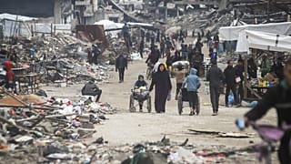 فلسطينيون يسيرون وسط الدمار الواسع الذي خلفه الهجوم البري والجوي للجيش الإسرائيلي في مخيم جباليا للاجئين في مدينة غزة، الجمعة 7 فبراير/شباط 2025