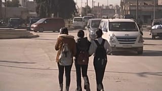 فتيات يمشين في شوارع كوباني فيما المدينة تتهيأ لمواجهة تقدم القوات الموالية لتركيا