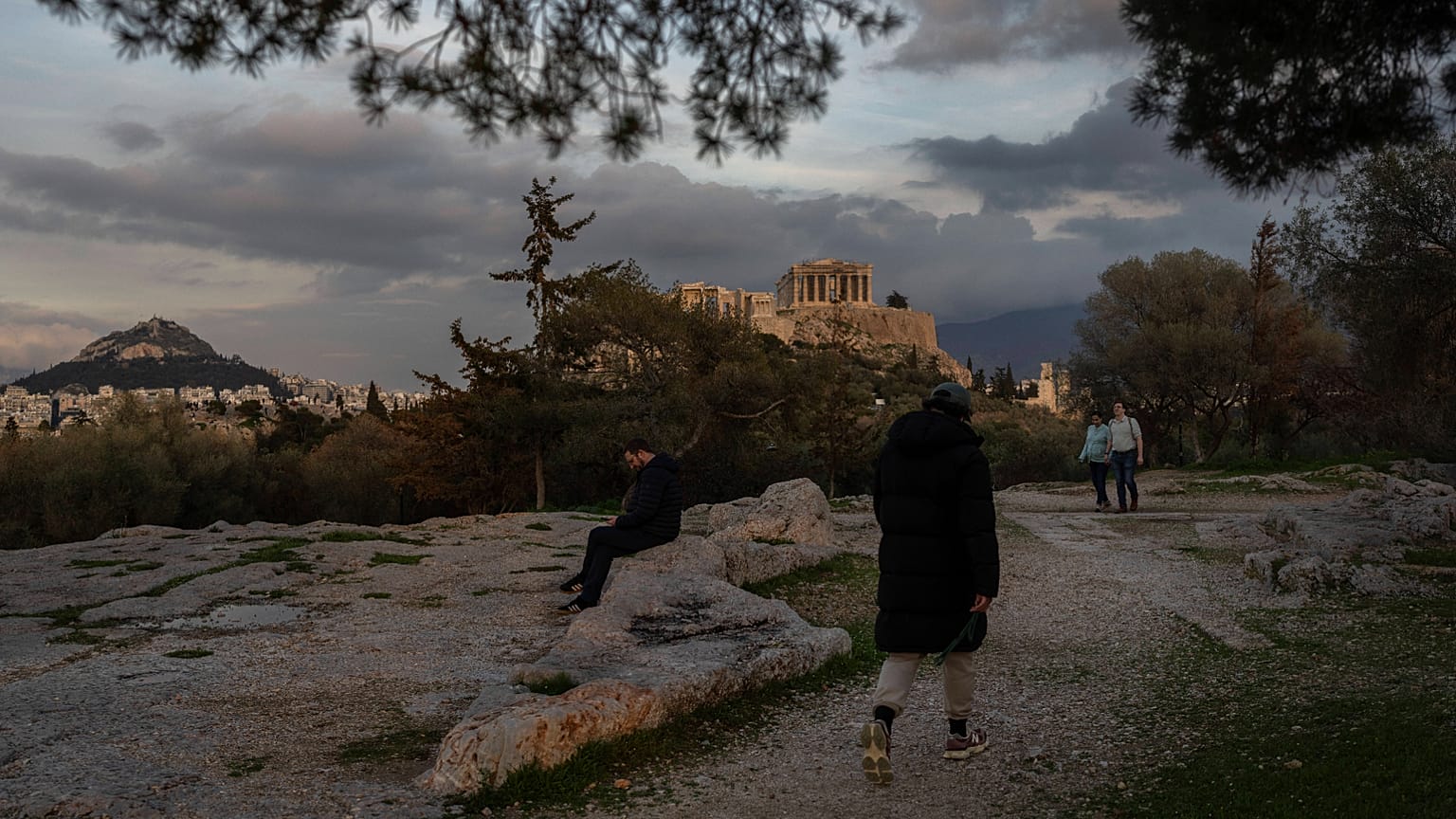 Passanti in un parco di Atene con l'Acropoli sullo sfondo (17 febbraio 2025)