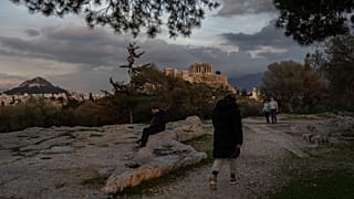 Passanti in un parco di Atene con l'Acropoli sullo sfondo (17 febbraio 2025)