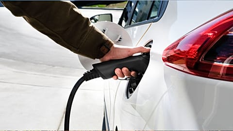 A person charging an electric car.
