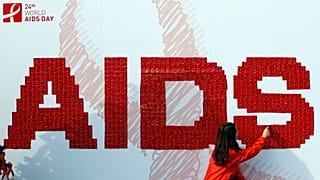 A woman attaches a condom on the board during an AIDS awareness campaign to increase awareness of the sexually-transmitted fatal disease in Seoul, South Korea, 2011.