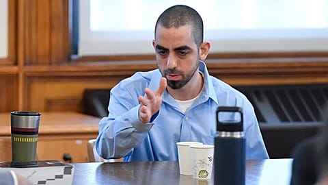 Hadi Matar, who's charged with severely injuring author Salman Rushdie in a 2022 knife attack, talks to his defence team in Chautauqua County court in Mayville, N.Y.