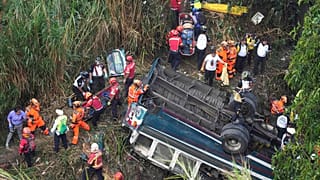 Firefighters work the scene of a fatal bus crash after it fell from a bridge on the outskirts of Guatemala City, Monday, Feb. 10, 2025