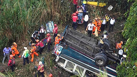 Firefighters work the scene of a fatal bus crash after it fell from a bridge on the outskirts of Guatemala City, Monday, Feb. 10, 2025